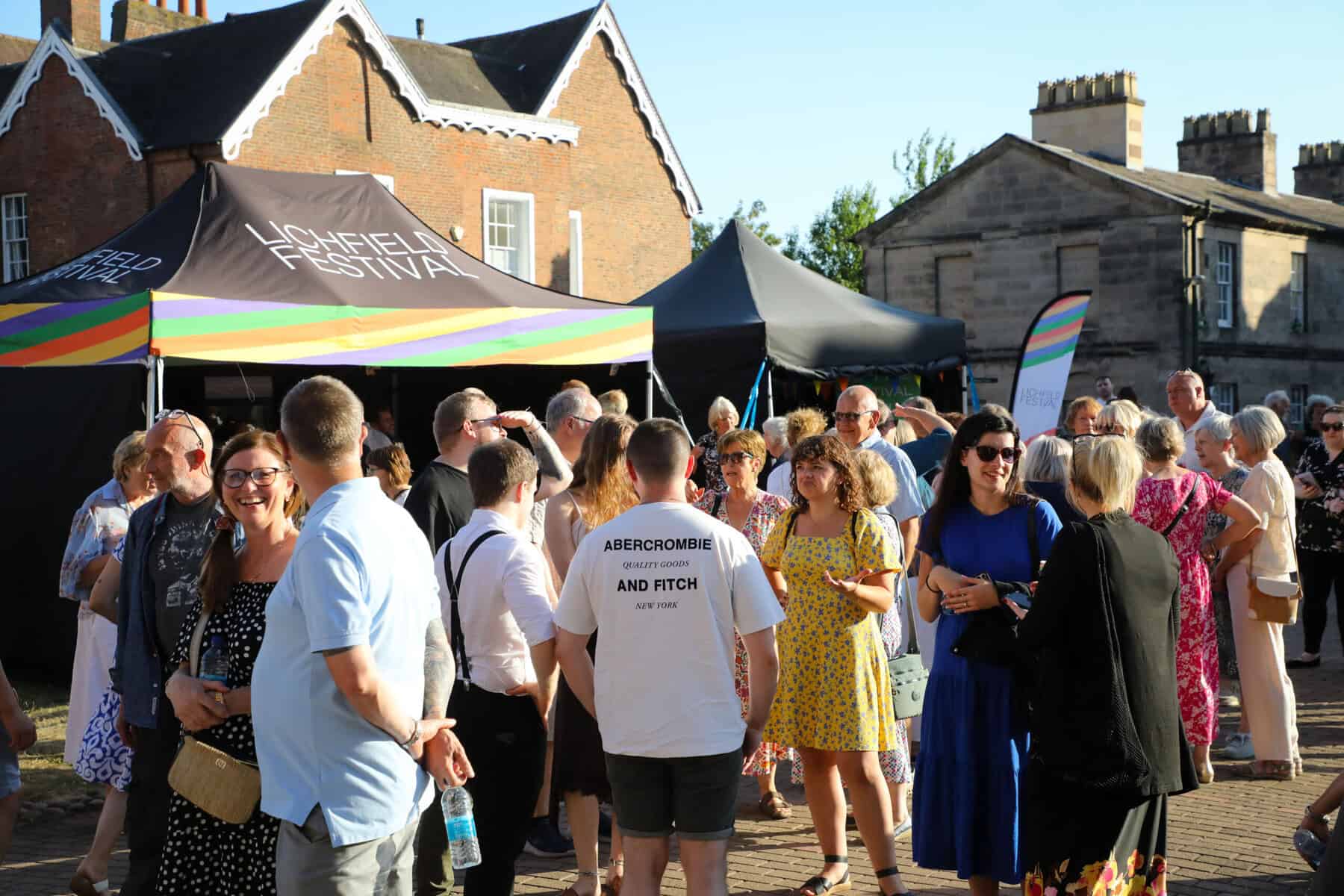 members of the public stand outside a Lichfield Festival gazebo