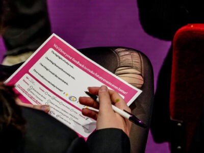 A student fills out a pink evaluation form