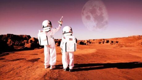 Two astronauts stand on a red planet