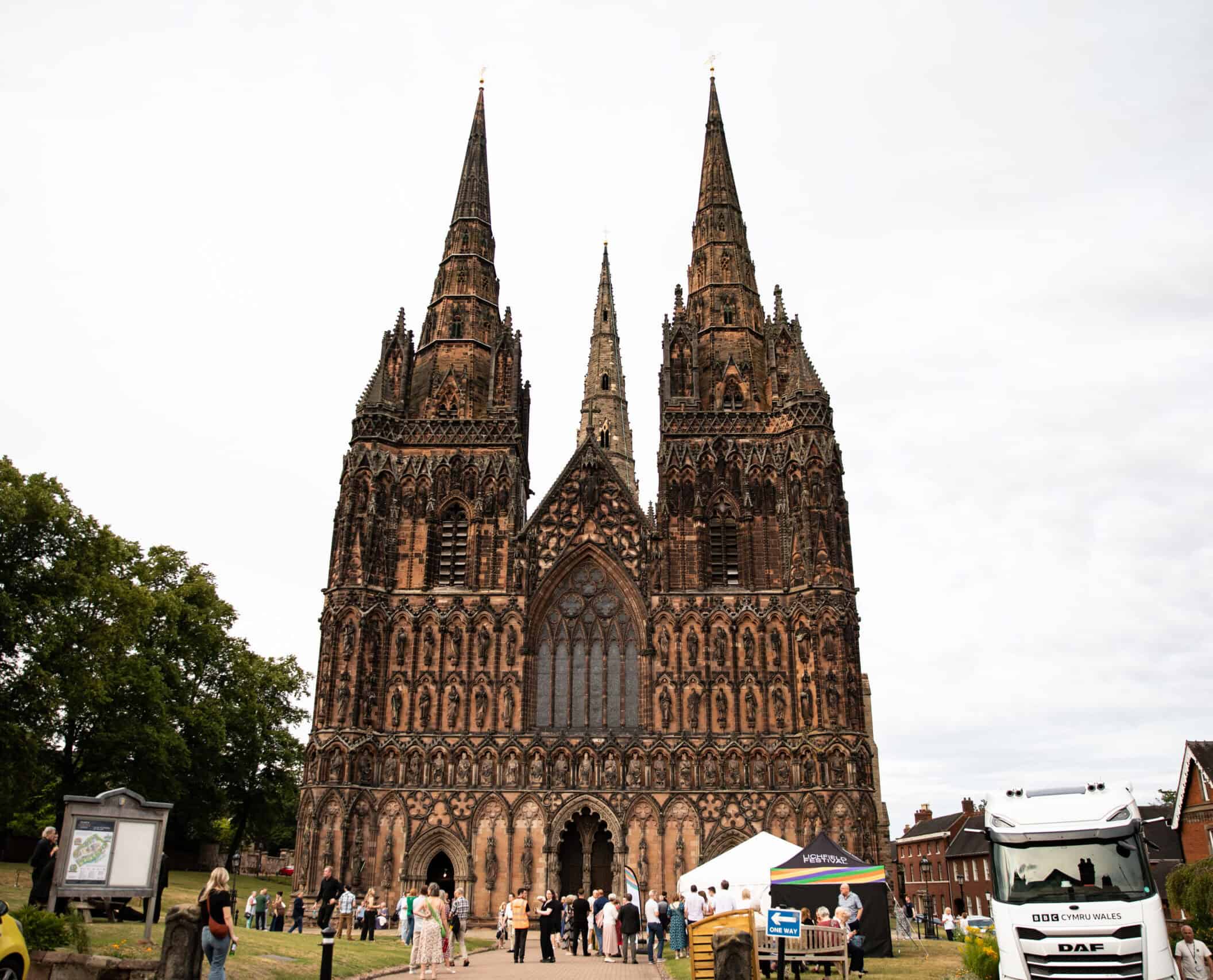 Lichfield Cathedral stands tall, with Festival attendees in the foreground.