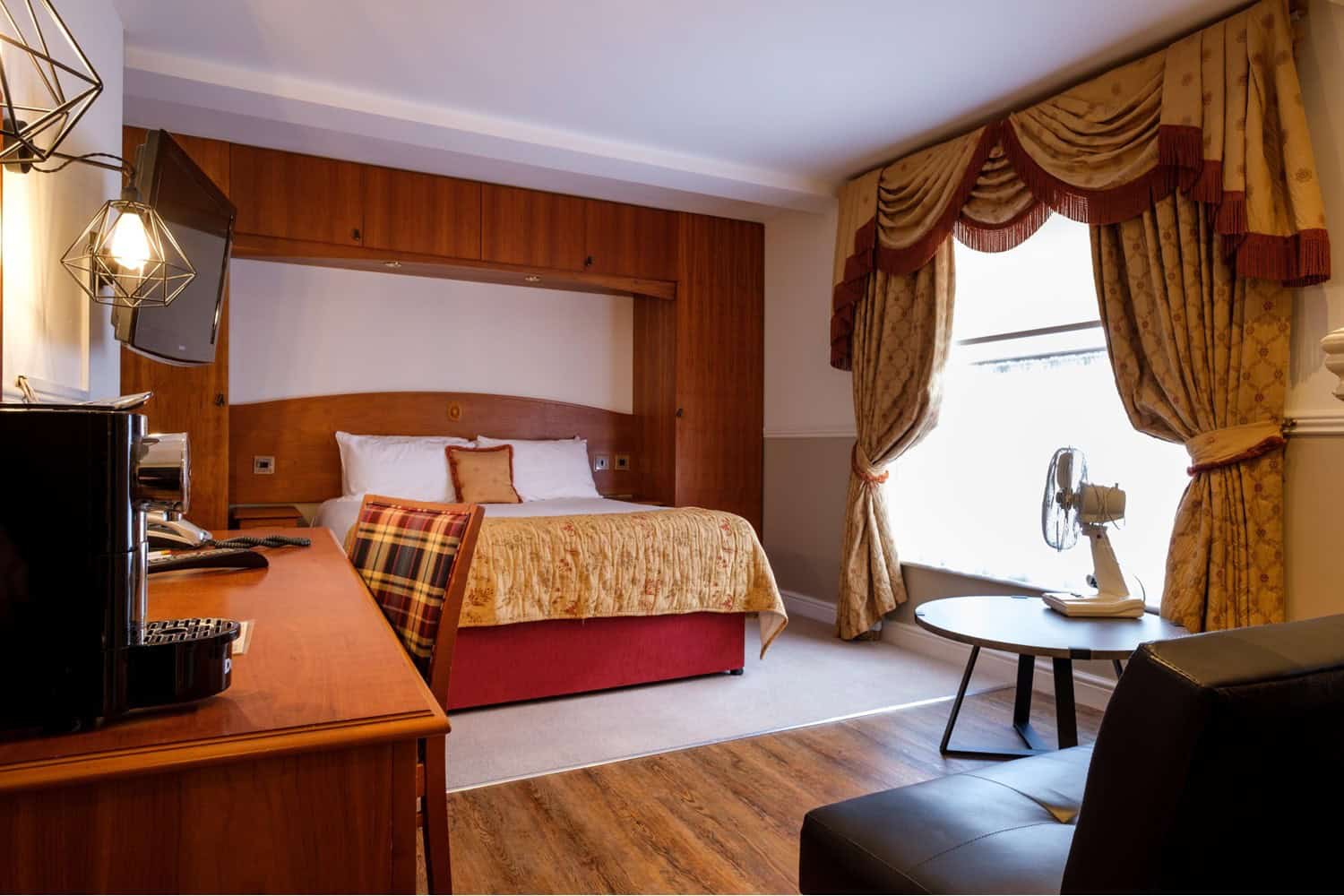 A double bed in an ornate hotel room